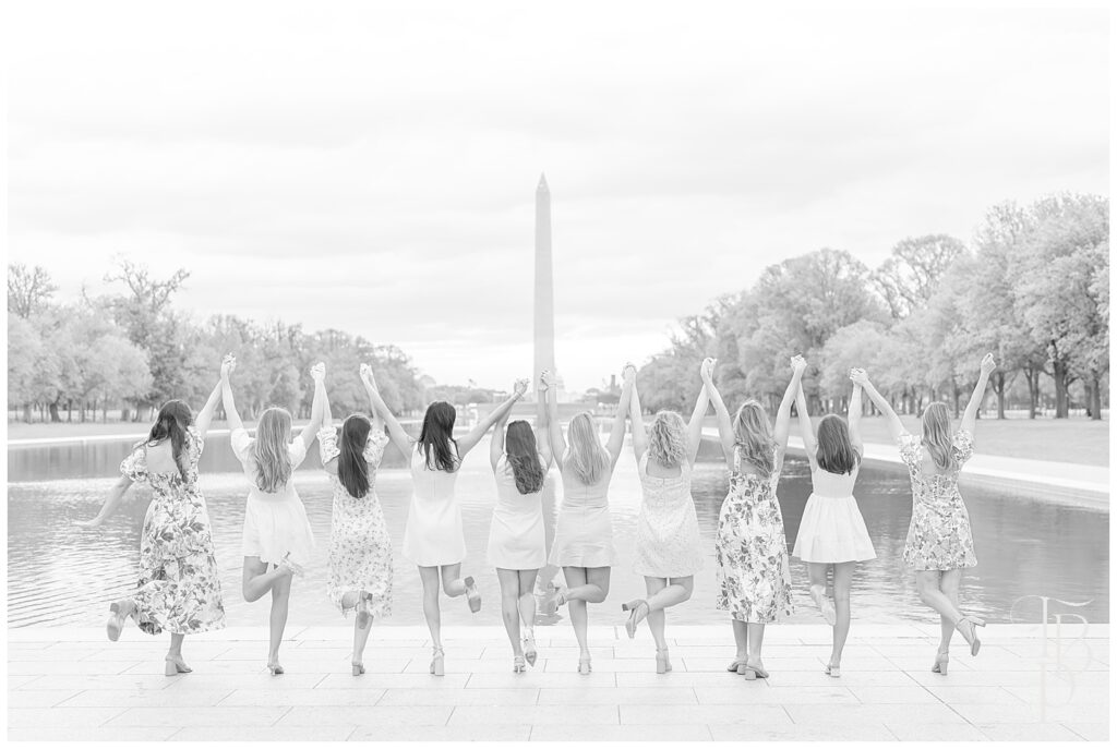 Friends holding hands in front of Washington Monument