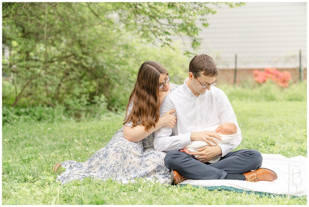 Parents looking at baby during Ashburn,VA outdoor newborn picture