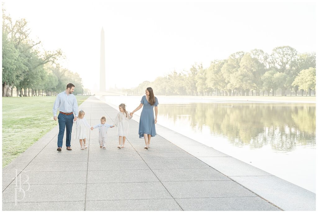 Family walking at Reflecting Pool with Washington Monument in the background