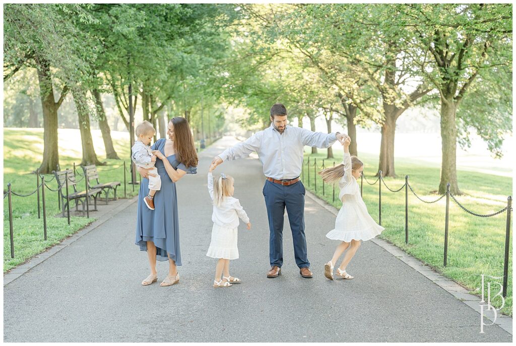 Mom playing with son, dad twirling daughters