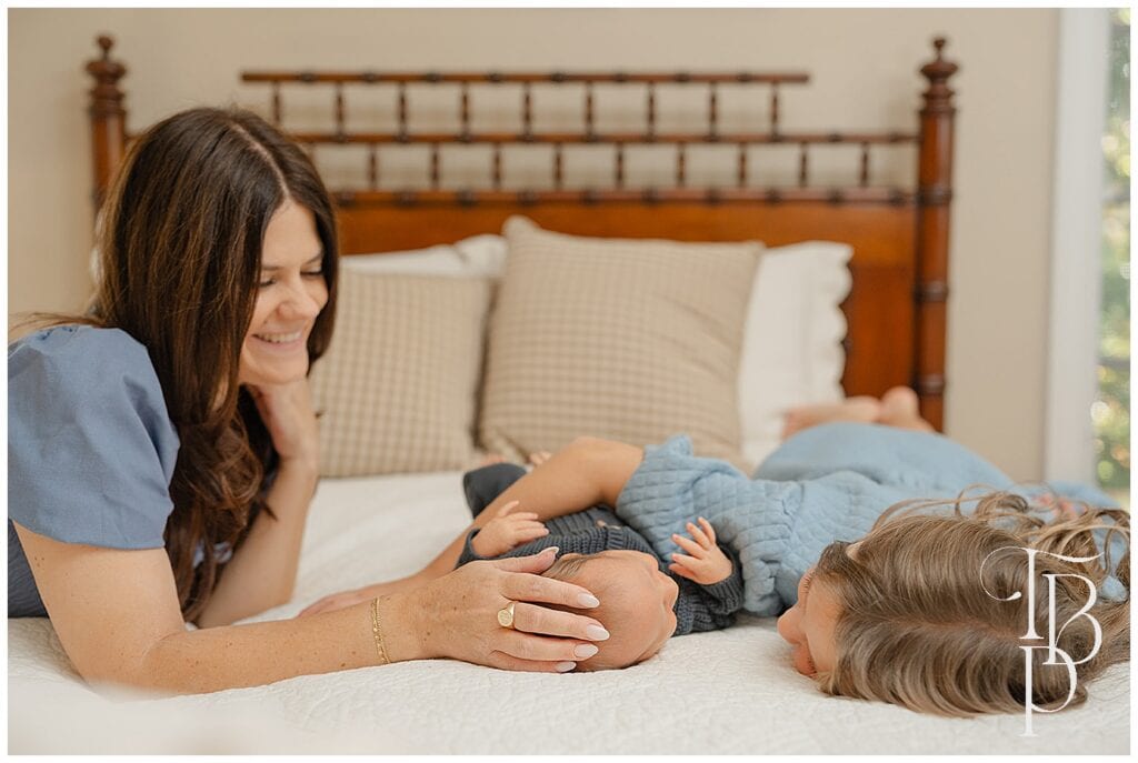 Mother playing with her child on a bed during in-home lifestyle family photos