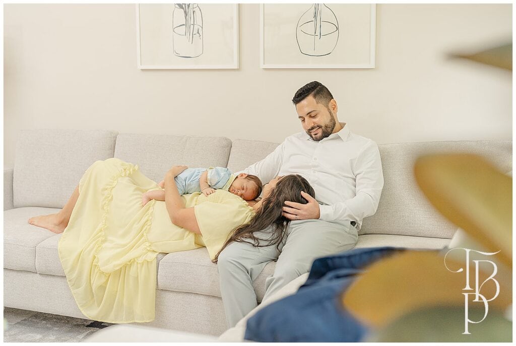 Parents cuddling their baby on the couch
