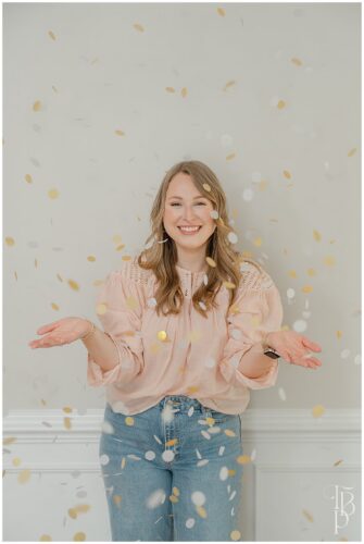 Business owner smiling as confetti falls around her during a branding photoshoot