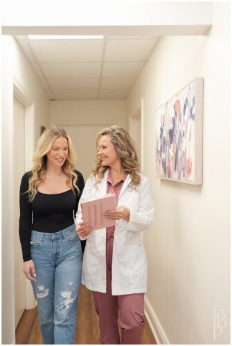 Healthcare professional and client walking together through a medical office hallway
